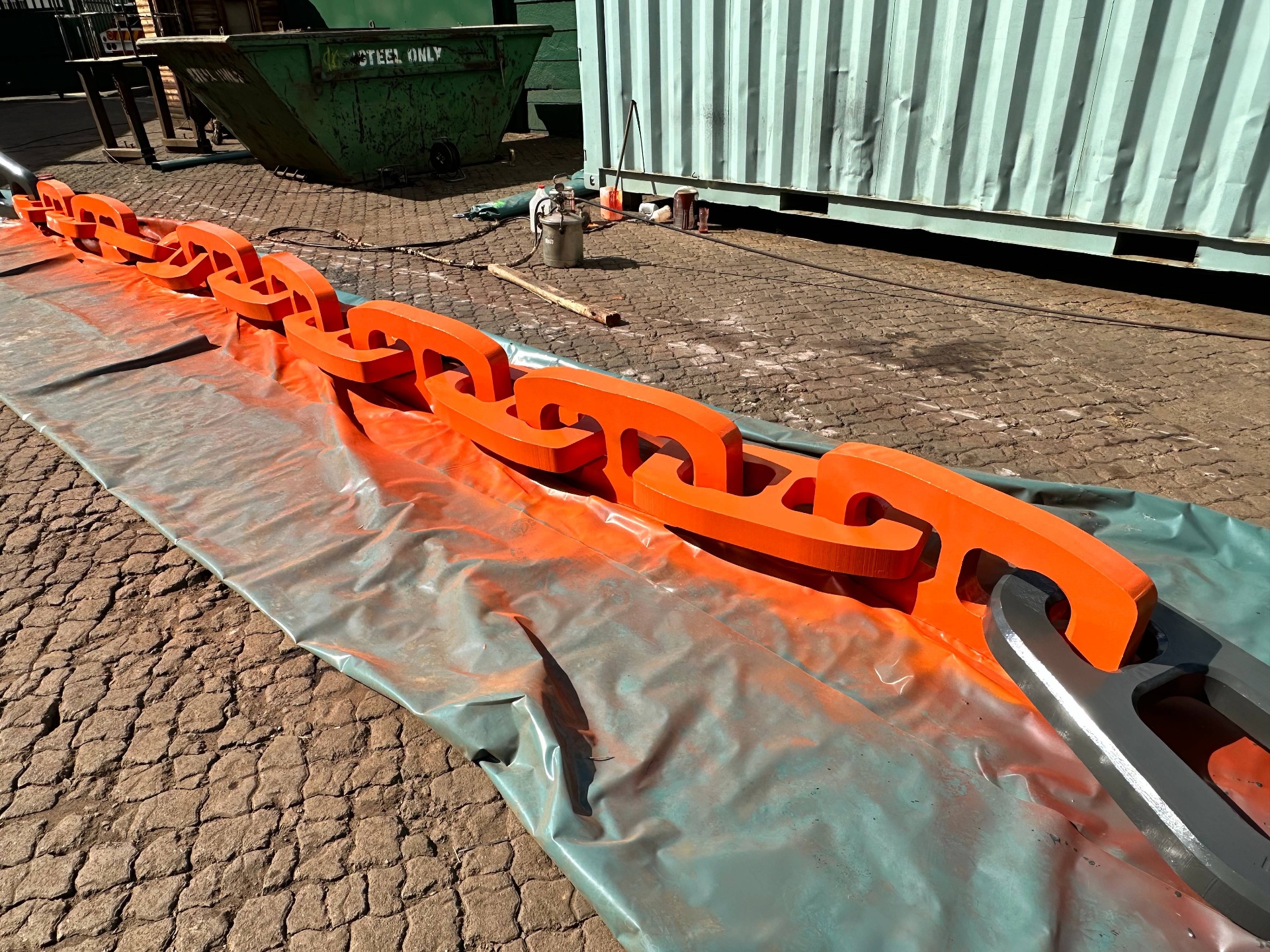 Completed dragline chain in vibrant orange, laid out end to end