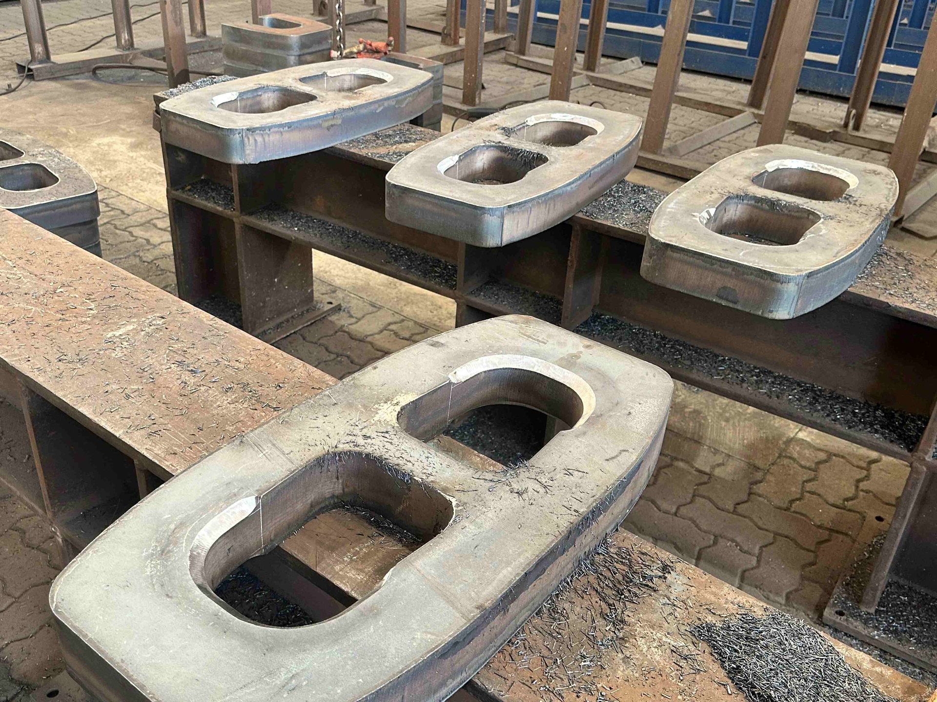 Profile-cut S690 chain link blanks laid out in the SPS workshop