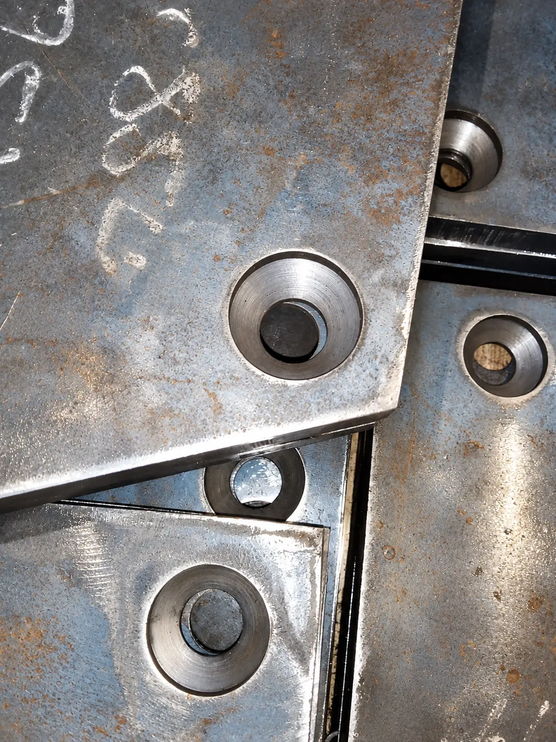 Close view of machined countersunk bolt seats in steel liner plates